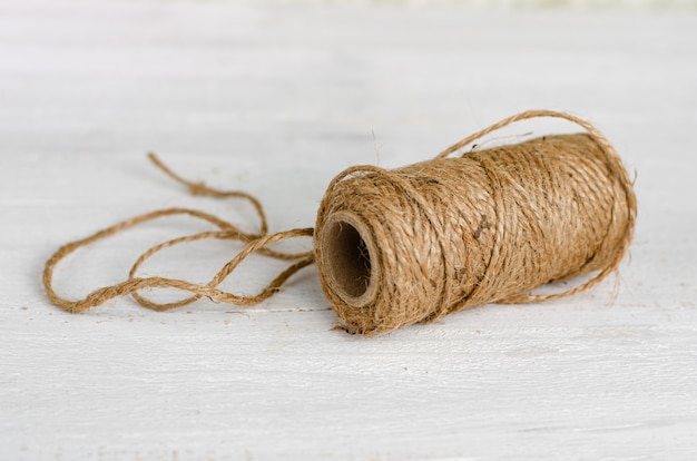 Rouleau de ficelle de jute naturel sur bois blanc