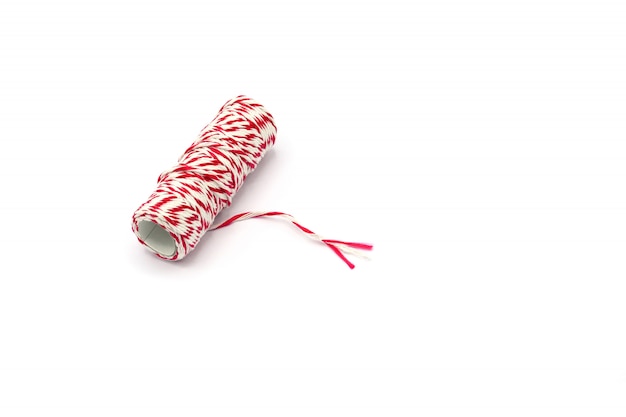 Rouleau de fil rouge et blanc isolé sur fond blanc