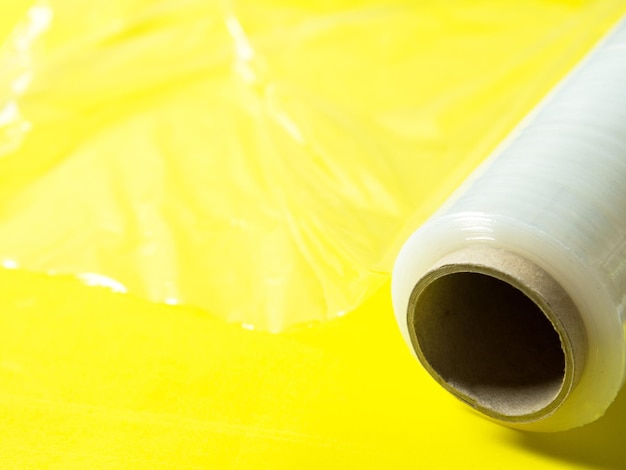 Photo rouleau de film étirable d'emballage pour l'emballage sur fond jaune isolé