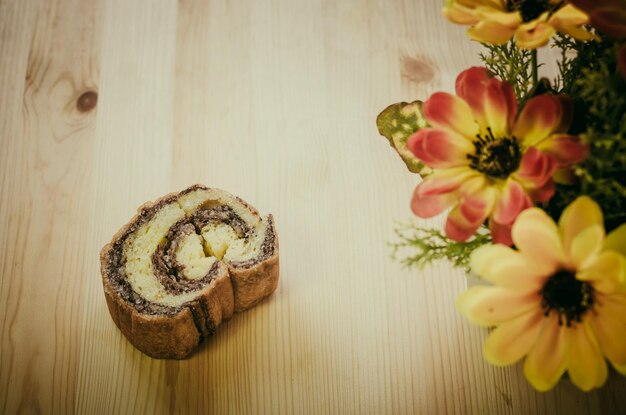 Rouleau de gâteau à la cannelle sur une table en bois dans un café rétro