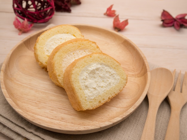 Rouleau de gâteau à la vanille sur une table en bois