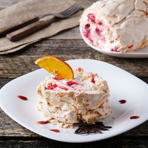 Rouleau de merengue à la framboise sur une assiette