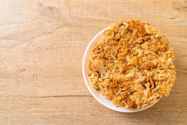 Rouleau de noix de coco croustillant avec porc râpé séché sur assiette