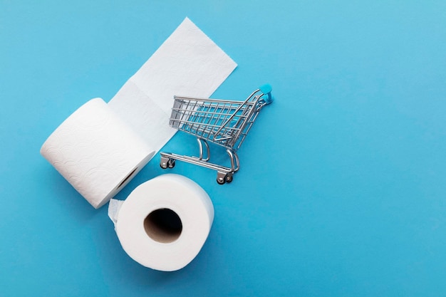 Rouleau de papier toilette blanc avec un caddie sur fond bleu