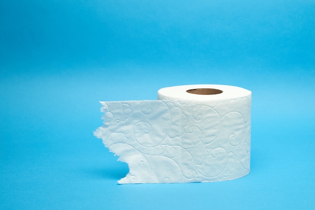 Rouleau de papier toilette blanc déchiré sur fond bleu minimaliste