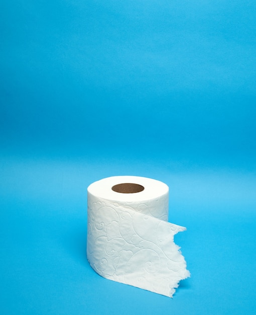 Rouleau de papier toilette blanc déchiré sur fond bleu minimaliste