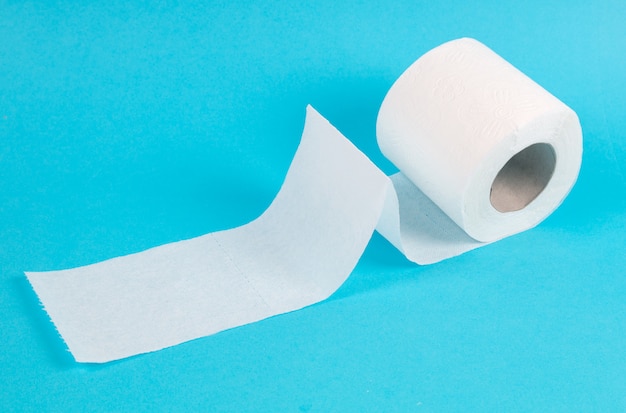 Rouleau de papier toilette blanc sur fond bleu