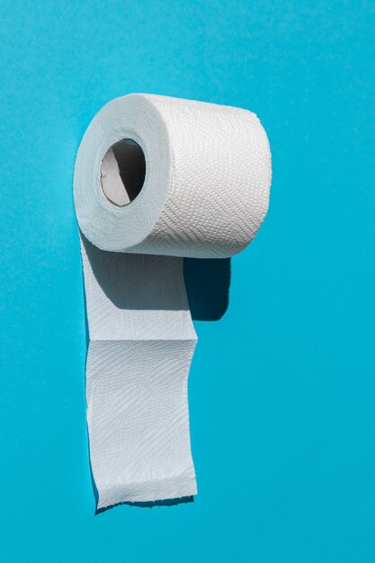 rouleau de papier toilette blanc isolé sur un gros plan de fond bleu