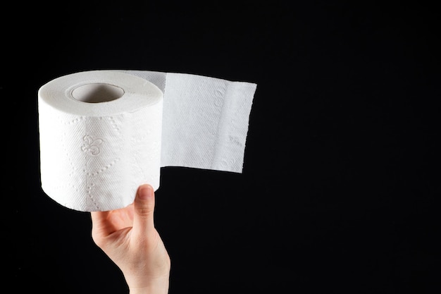 Un rouleau de papier toilette doux blanc dans la main d'un homme