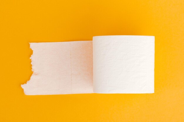 Rouleau de papier toilette sur fond jaune