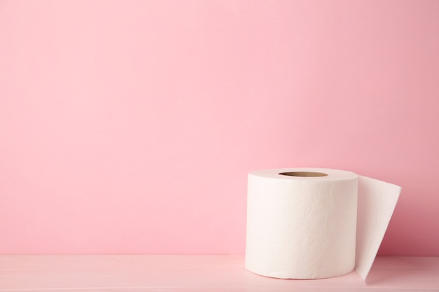 Rouleau de papier toilette sur fond rose