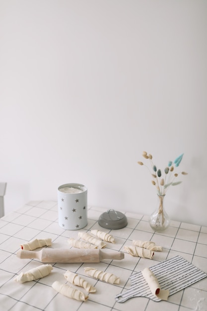 Rouleau à pâtisserie en bois fait maison avec de la pâte sur la table de la cuisine