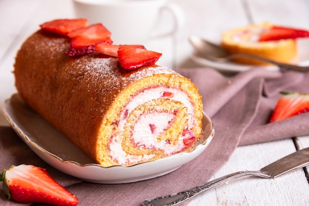 Rouleau suisse avec des fraises et de la crème dessert fait maison