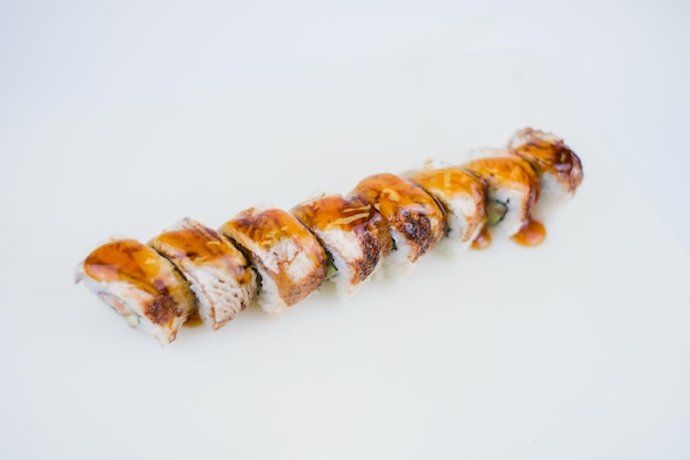 Un rouleau de sushi à l'anguille et à la sauce unagi sur une assiette de cuisine japonaise