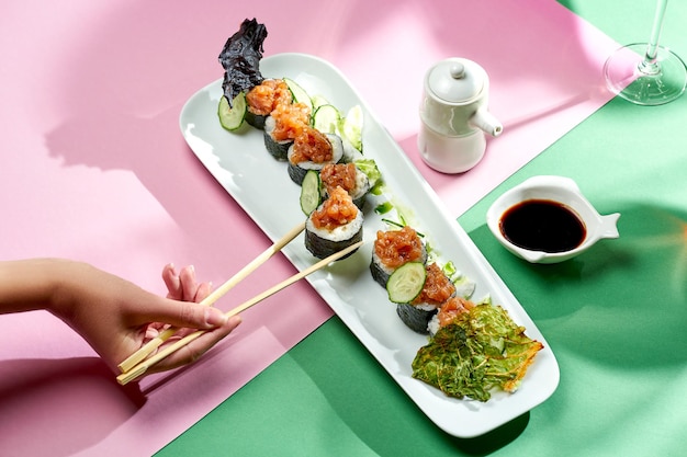 Rouleau de sushi au thon et concombre dans une assiette d'arrière-plans lumineux. Mise au point sélective, ombres dures
