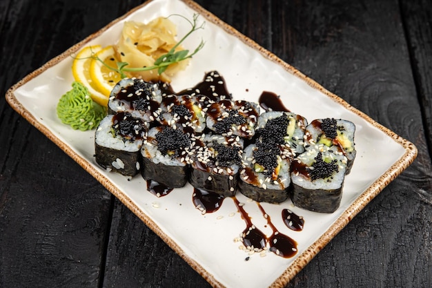 rouleau de sushi au wasabi et graines de sésame sur l'assiette. nourriture délicieuse, gros plan