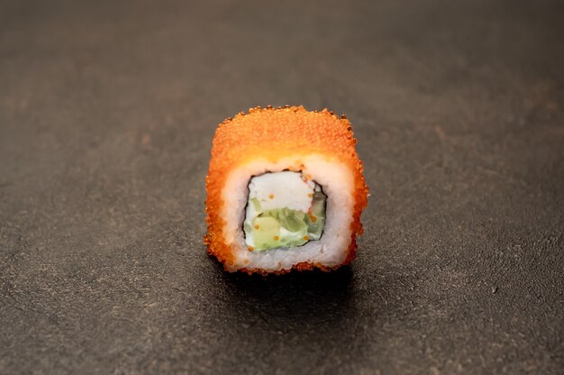 un rouleau de sushi sur un fond de pierre