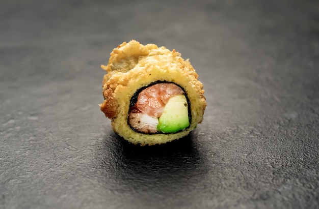 un rouleau de sushi sur un fond de pierre