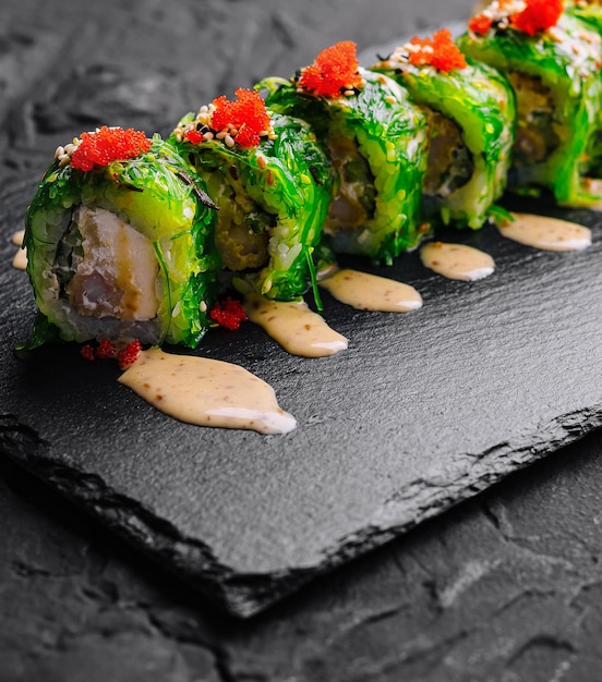 Photo un rouleau de sushi frais avec du tobiko sur l'ardoise