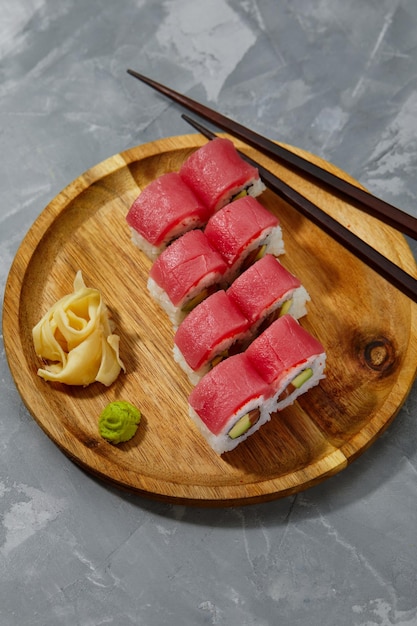 Rouleau de sushi Maguro au thon crevette saumon anguille fumée avocat fromage philadelphie sur fond noir menu sushi cuisine japonaise