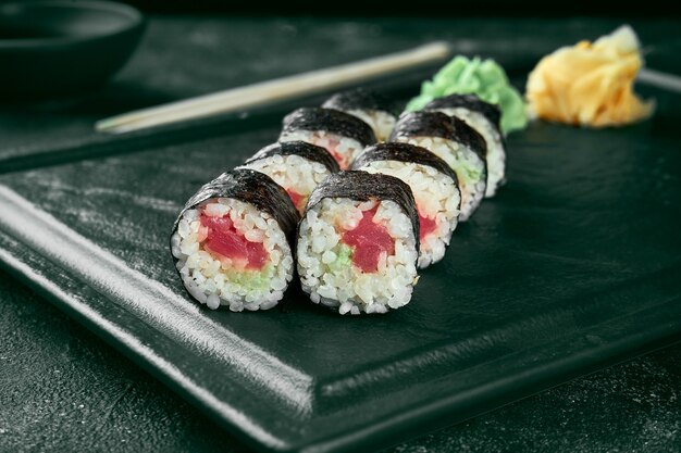 Rouleau de sushi maki au saumon. Cuisine japonaise classique. Livraison de nourriture. Fond noir