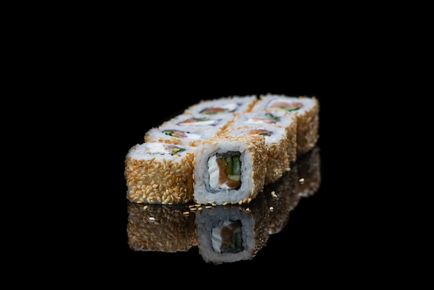 Rouleau de sushi sur une réflexion de mur noir. Nourriture japonaise. Fermer.