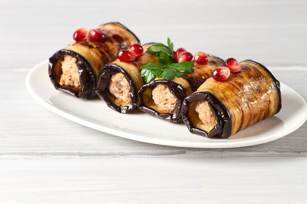 Photo rouleaux d'aubergines de cuisine géorgienne avec garniture aux noix et épices sur une table en bois horizontale sans peuple