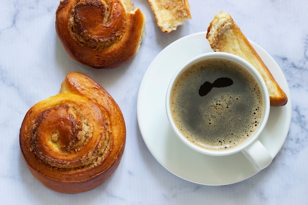 Rouleaux à la cannelle fourrés aux noix, servis avec du café.