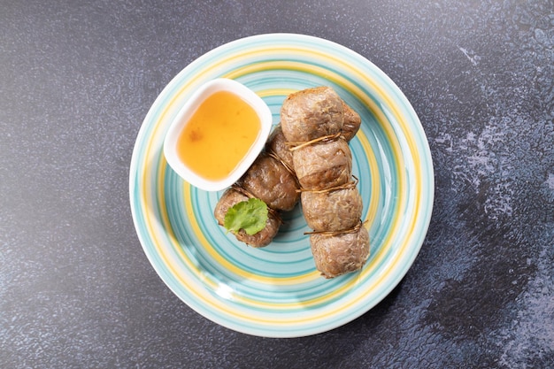 Des rouleaux de chair de crabe frits avec une trempette sont placés sur une assiette.