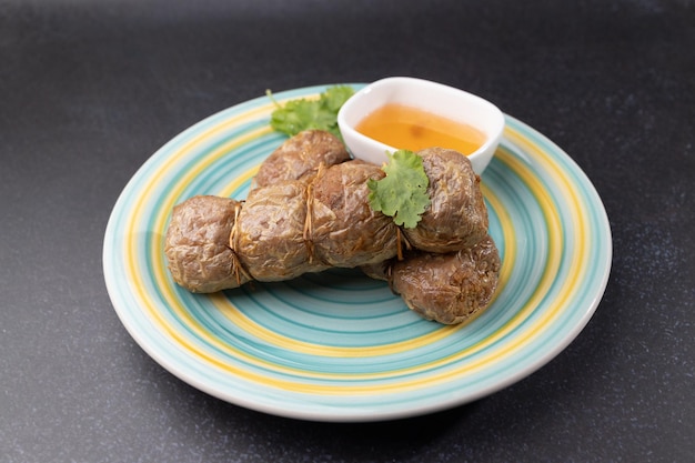 Des rouleaux de chair de crabe frits avec une trempette sont placés sur une assiette.