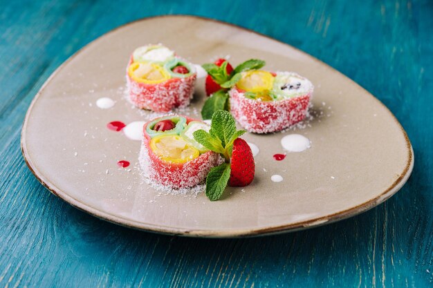 Rouleaux de crêpes roses avec différents fruits et baies