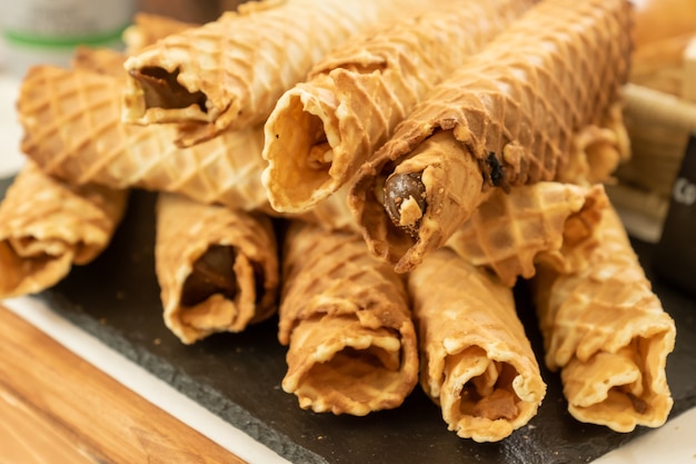 Rouleaux de gaufres maison avec du lait concentré sur buffet.