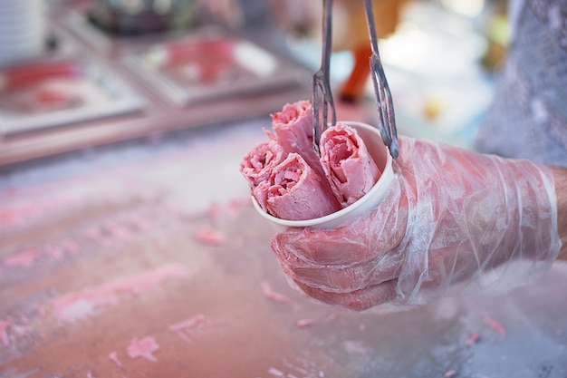 Rouleaux De Glace Naturelle Dans Une Tasse. La Main Tient Une Tasse De Glace