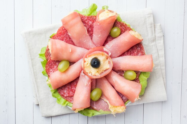 Rouleaux de jambon au fromage et saucisses sur une assiette