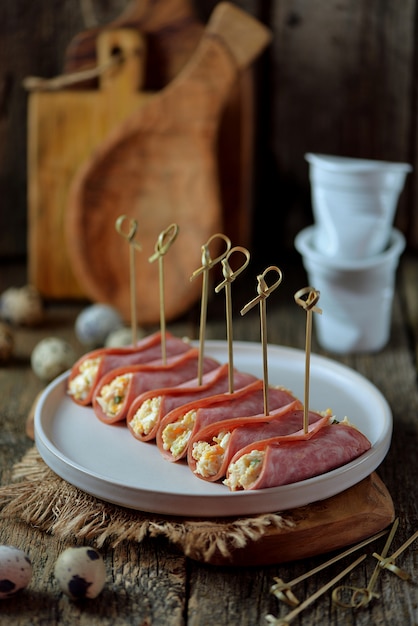 Rouleaux de jambon avec fromage à pâte molle, œufs durs et oignons verts.