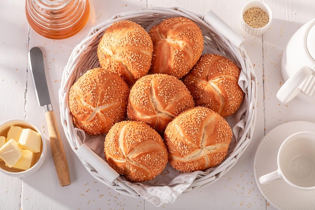 Rouleaux Kaiser faits maison avec des graines de sésame dans un panier blanc