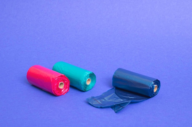 Rouleaux multicolores de sacs en plastique sur fond bleu