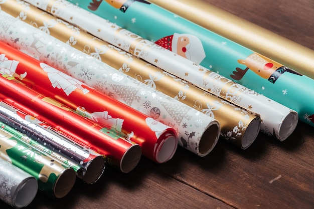 Rouleaux de papier d&#39;emballage de modèle de Noël sur fond de bois rustique