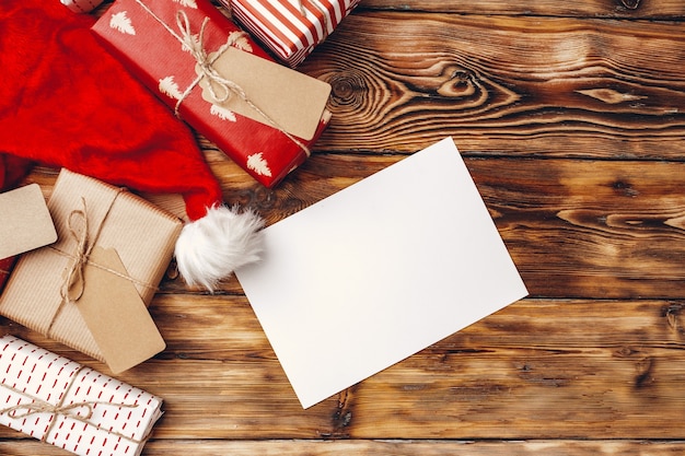 Photo rouleaux de papier d'emballage pour les cadeaux de noël sur planche de bois brun, mise à plat, vue du dessus