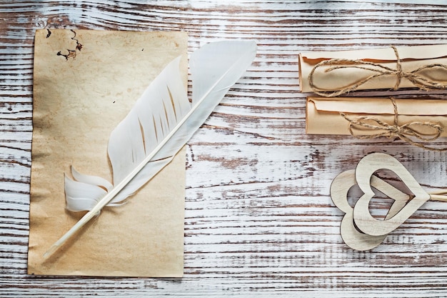 Rouleaux de papier feuille médiévale panache coeurs en bois sur le concept de célébrations de planche de bois vintage
