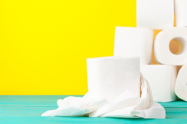 Rouleaux de papier hygiénique empilés sur du papier jaune