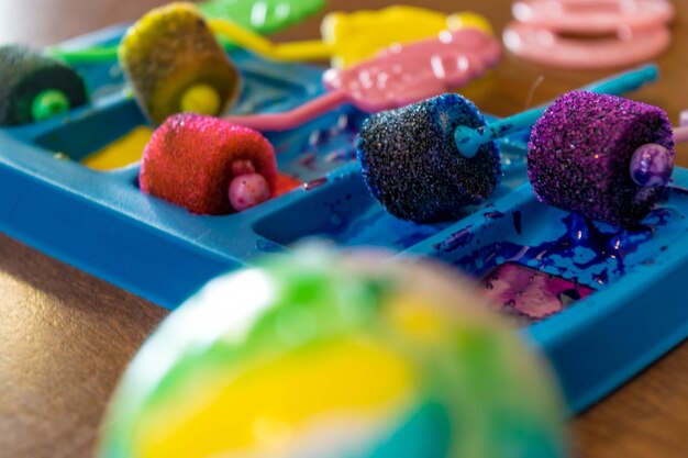 Photo des rouleaux de peinture colorés dans un plateau sur la table