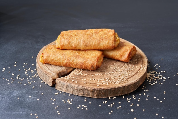 Rouleaux de printemps frits sur une planche de cuisine en bois