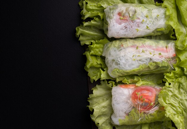 Photo rouleaux de printemps végétariens aux légumes sur fond noir.