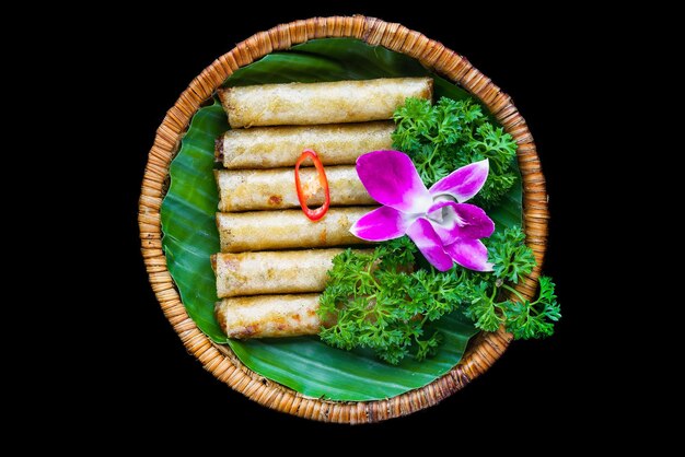 Rouleaux de printemps vietnamiens frits traditionnels avec papier de riz au porc sur fond noir vue latérale