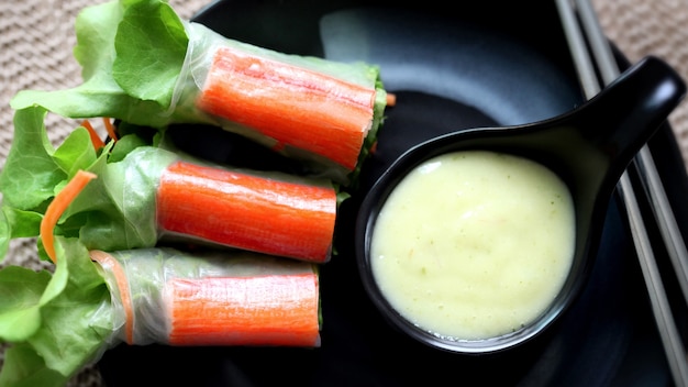 Rouleaux de salade au crabe sur un plat noir