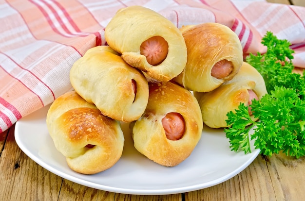 Rouleaux De Saucisses Sur Une Assiette, Persil, Serviette Contre Une Planche De Bois