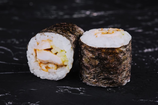 Rouleaux de sushi à l'anguille sur fond noir