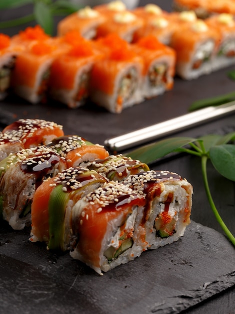 Rouleaux de sushi sur des assiettes colorées sur fond noir