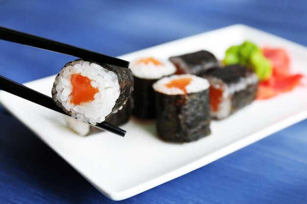 Rouleaux de sushi au saumon sur plaque sur fond de bois